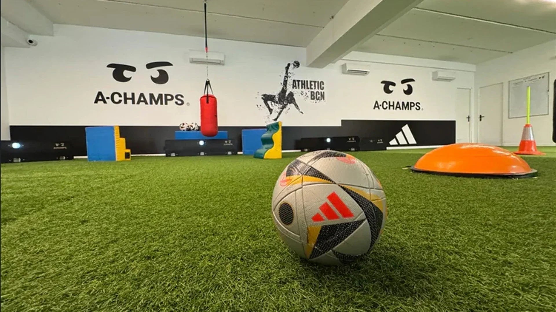 Indoor sports facility with training equipment and ACHAMPS branding on the wall.